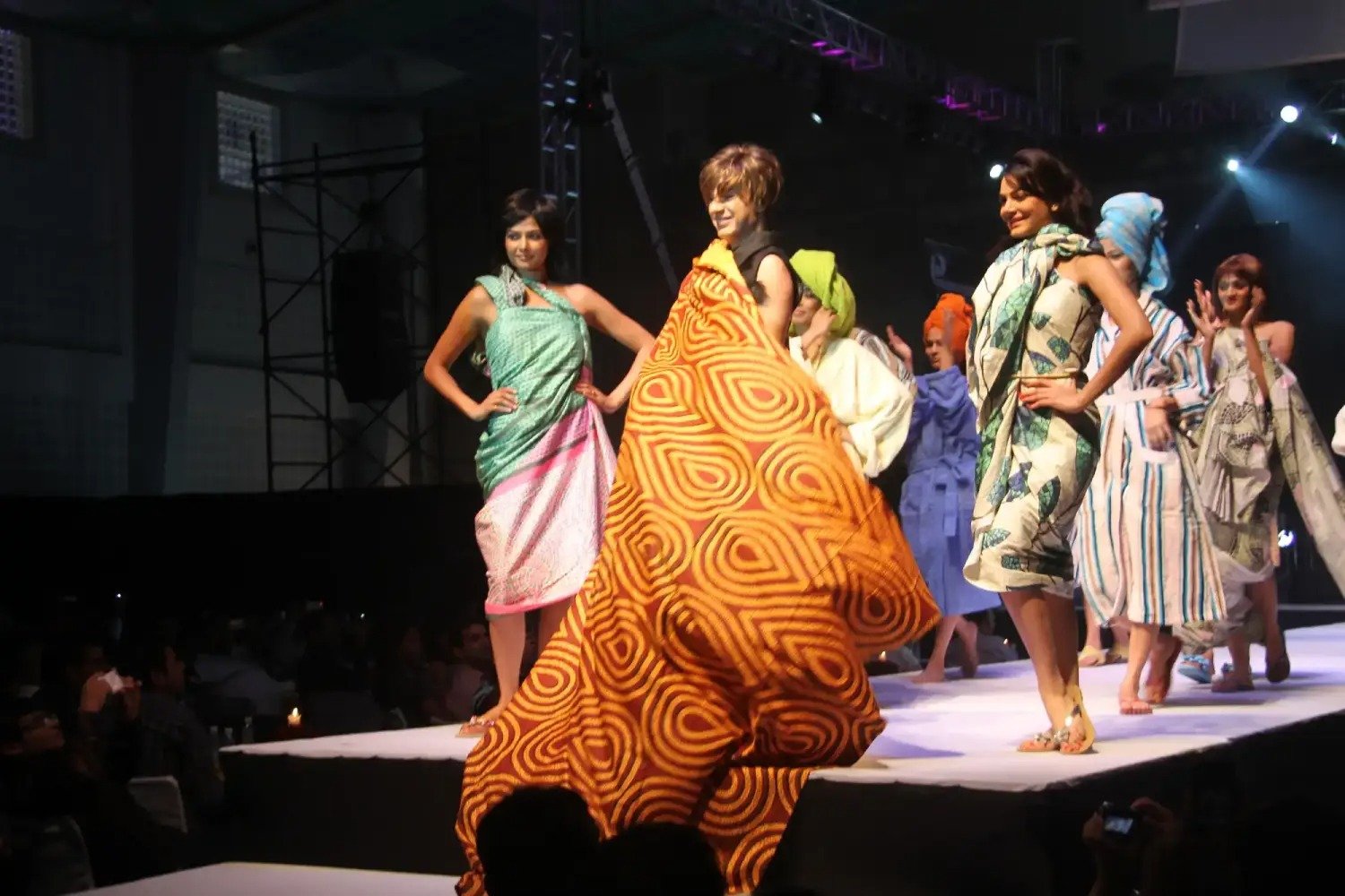Man and woman speaking on stage at night with blue lighting